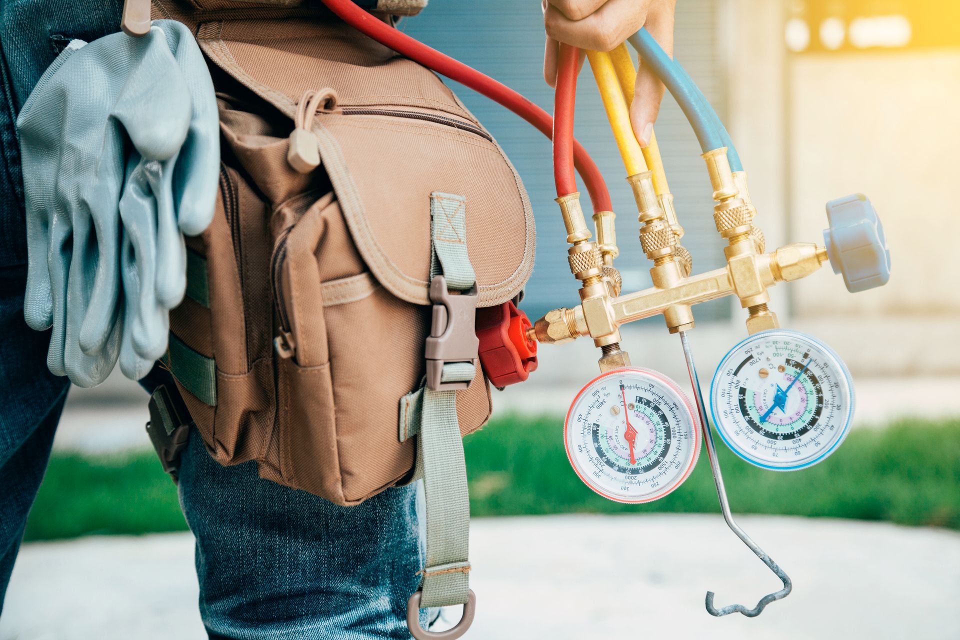 A man is holding a pair of gauges and a hose.