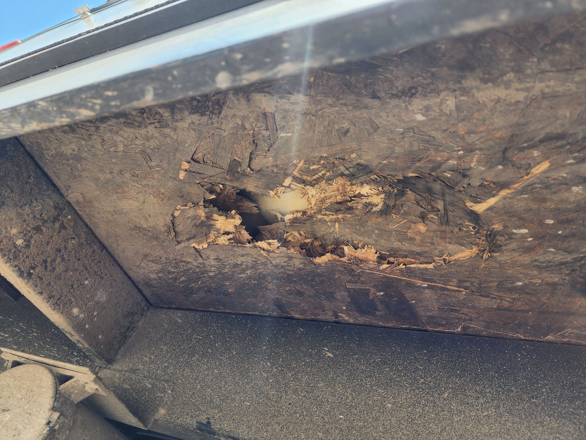 Damaged, crumbling wooden panel with a hole, potentially water damaged.