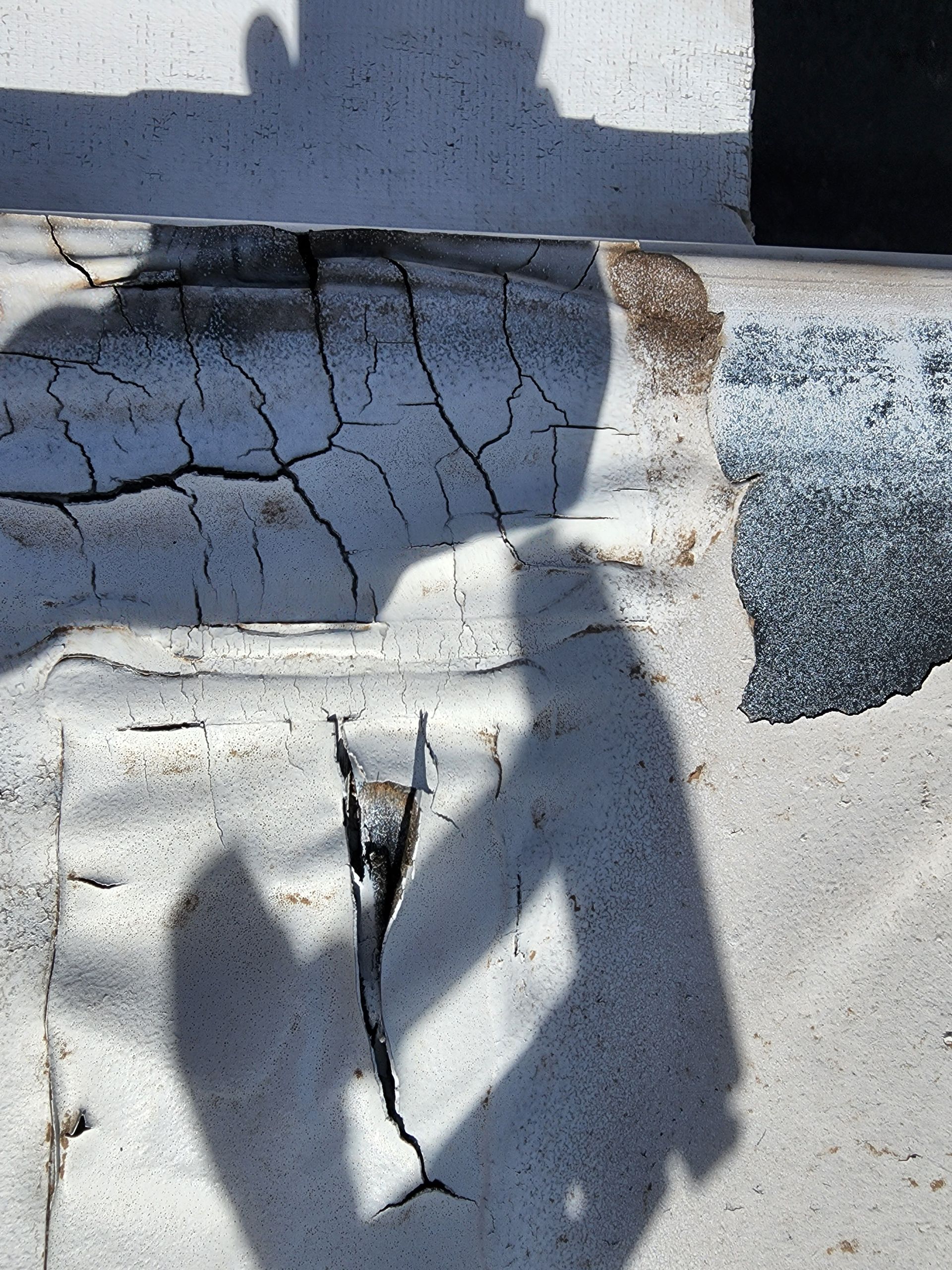 White surface with cracks and shadow.