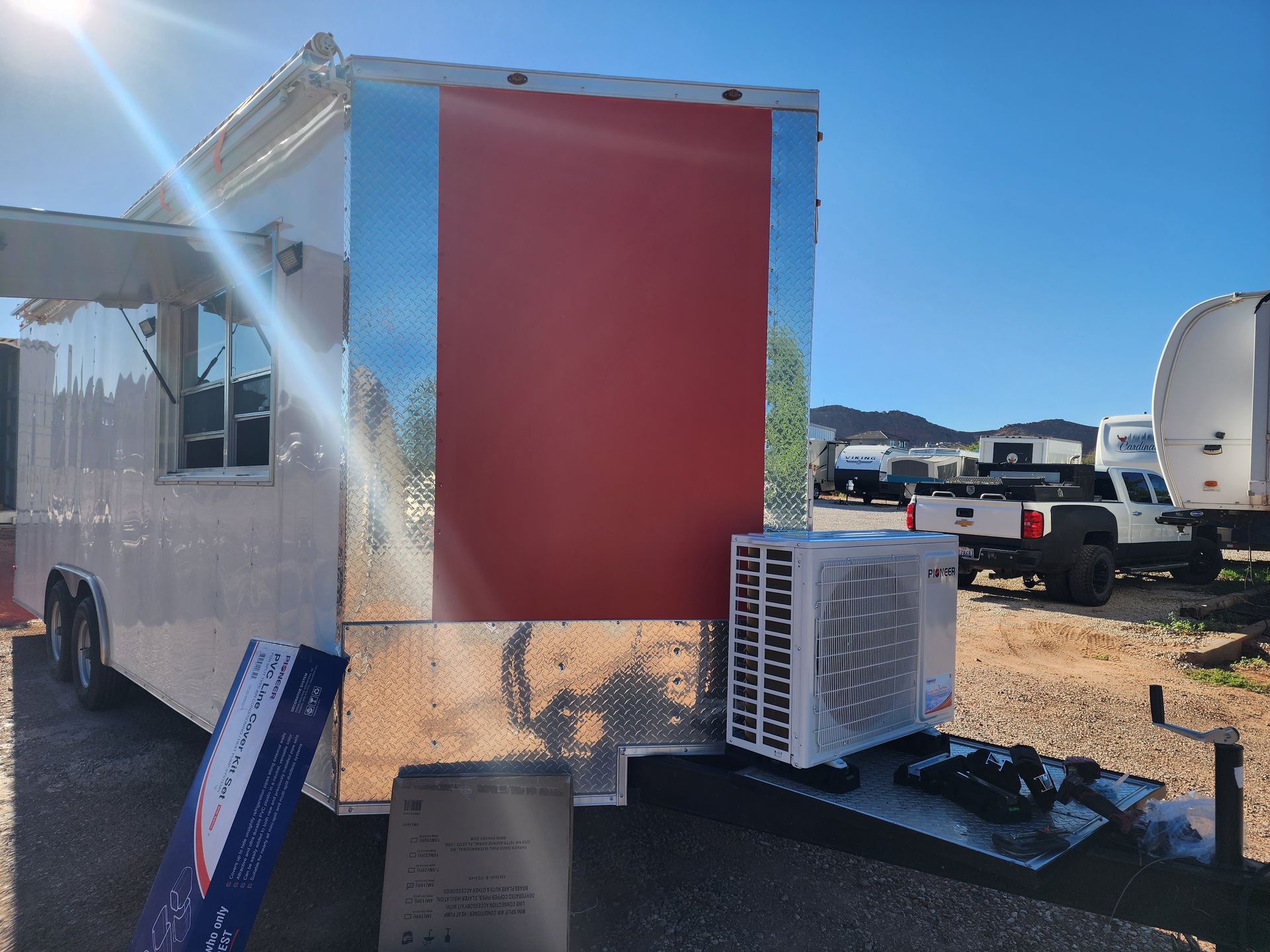 Food truck with red panel and air conditioning unit.