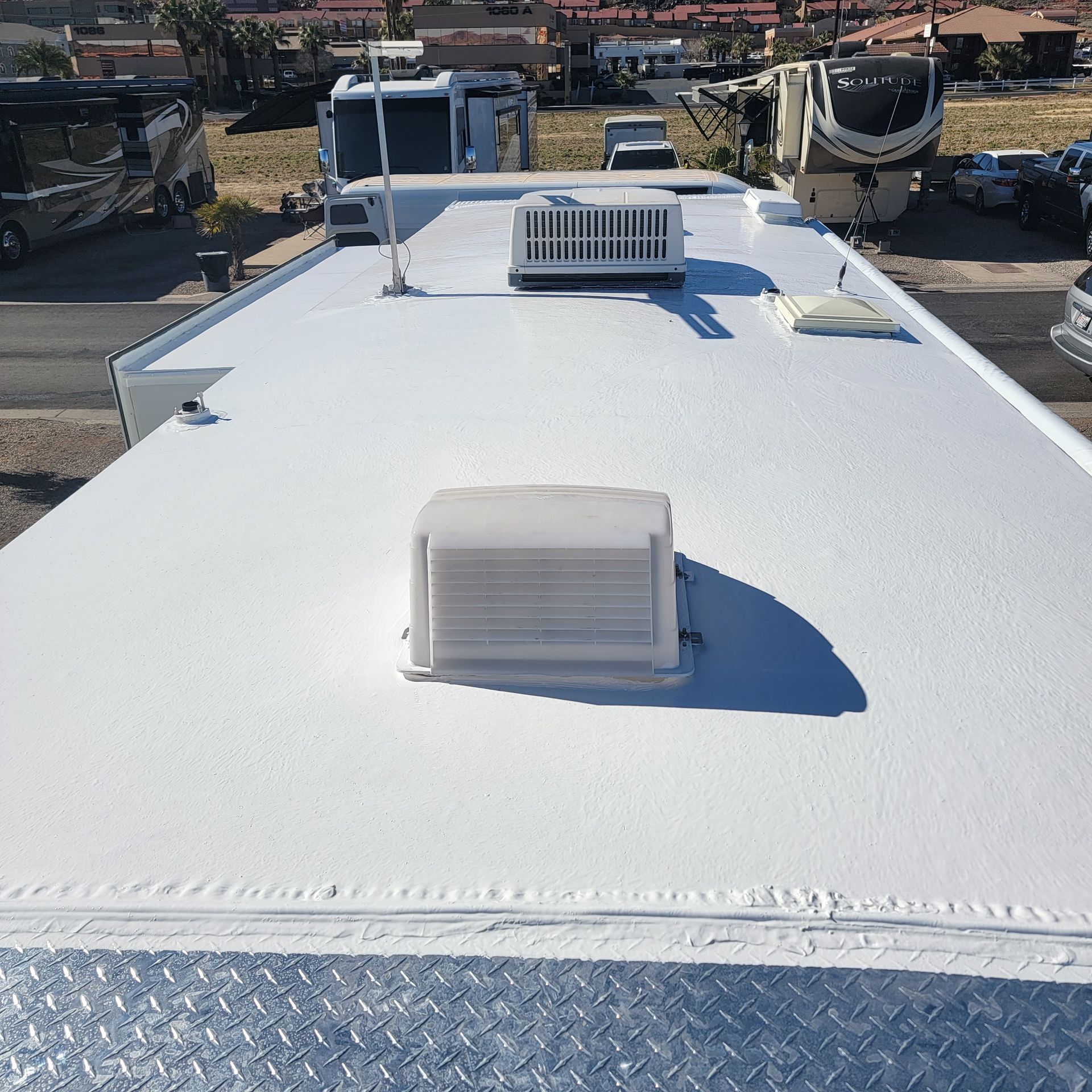White RV roof with air conditioning units and antenna.