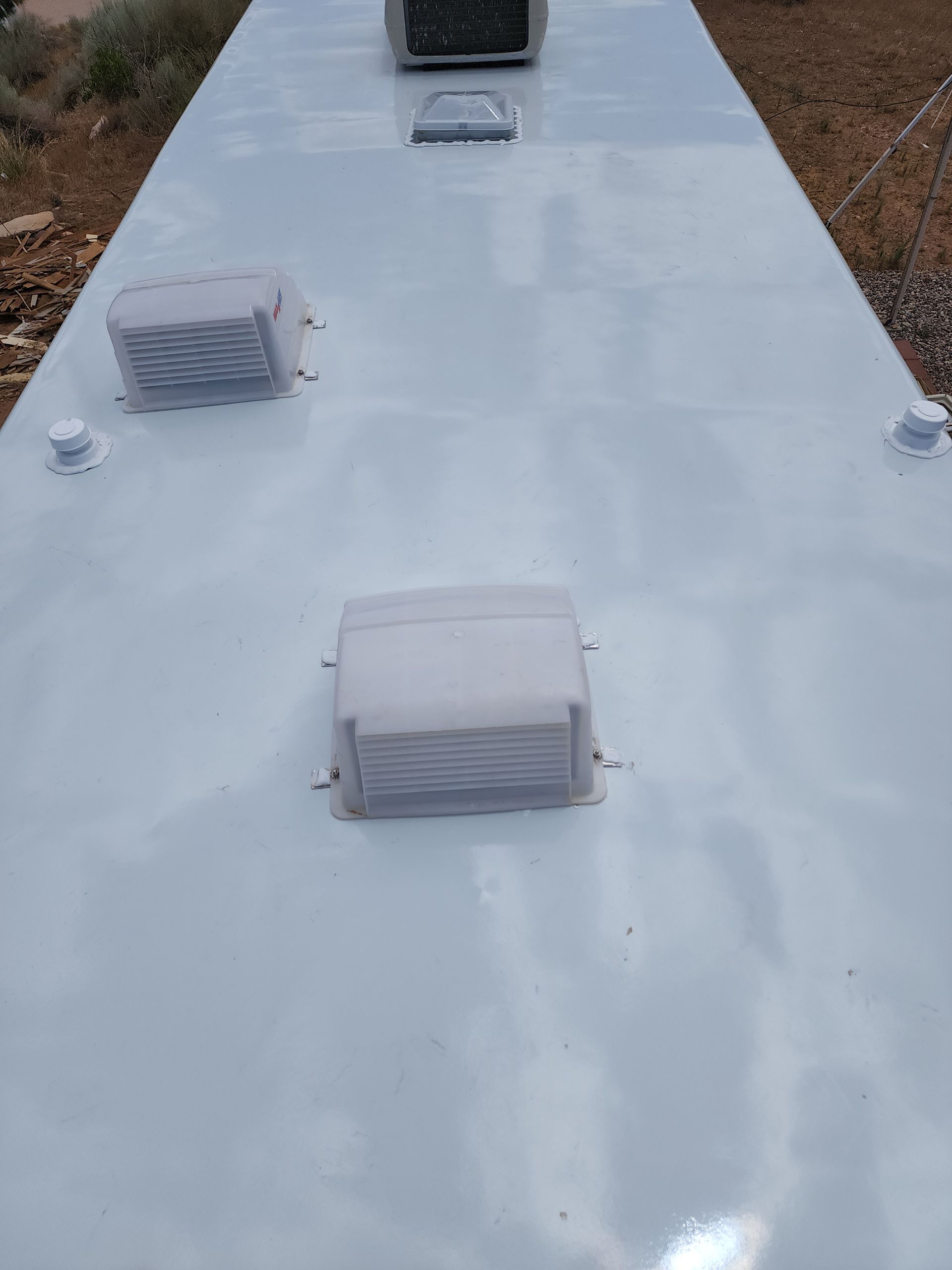 White RV roof with vents and air conditioning unit.
