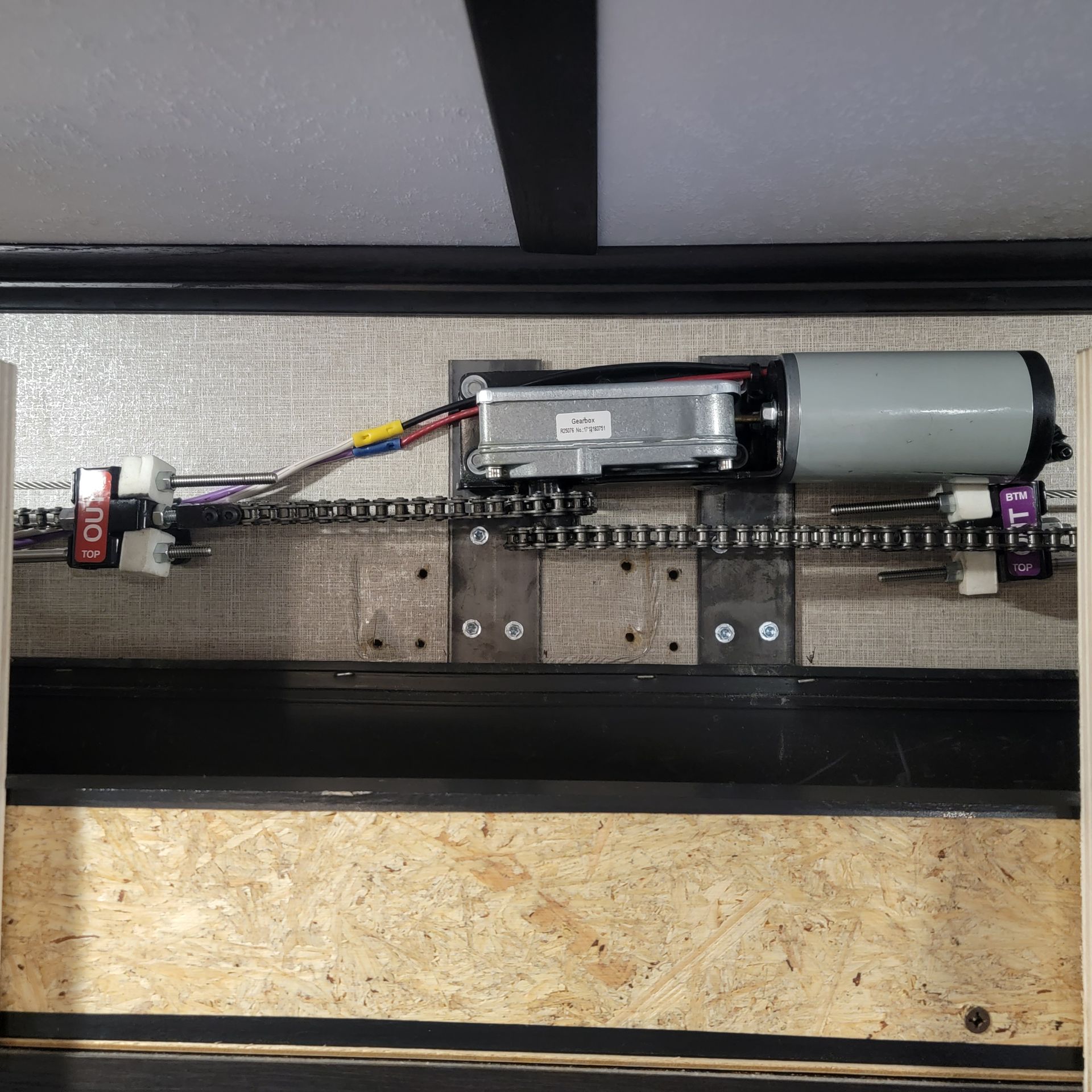 Motorized chain drive system for RV slide-out, with motor, controller, chain, and sprockets.