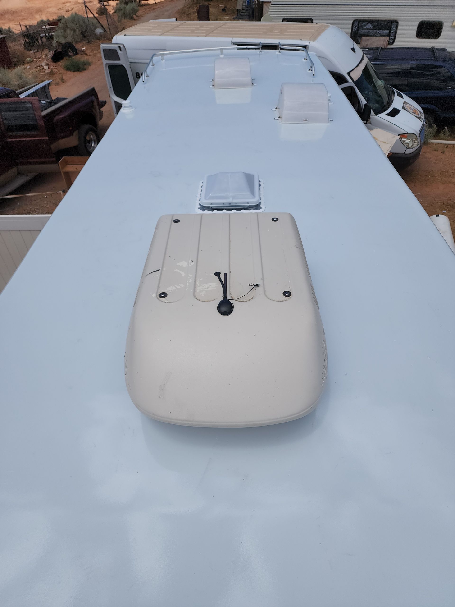 White RV roof with vents and satellite dome.