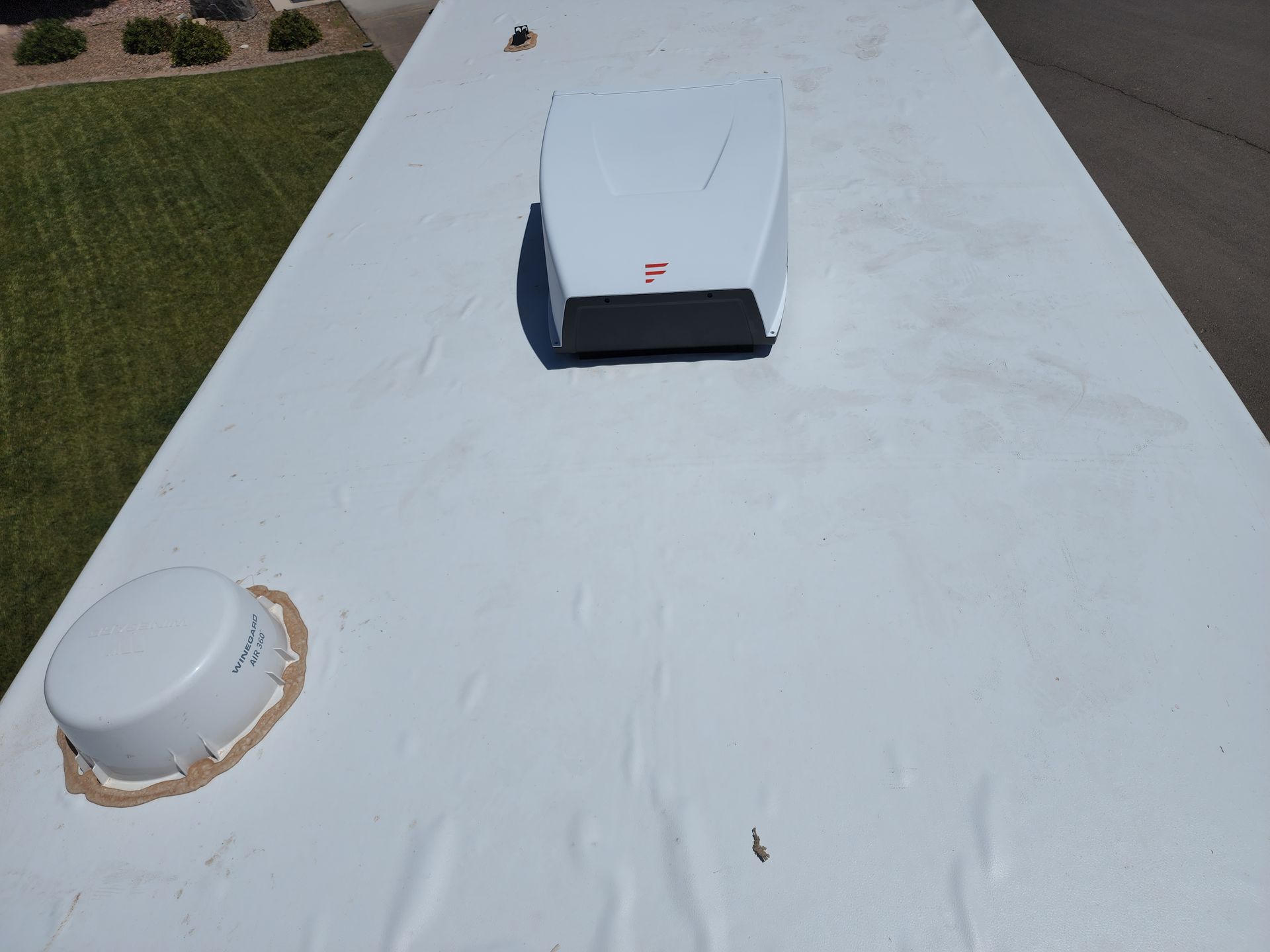 White RV roof with a vent and satellite dish.