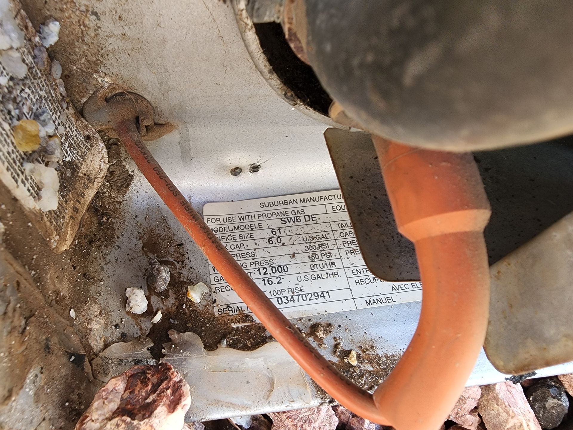 Orange cable connected to metal component, with debris in the corner.