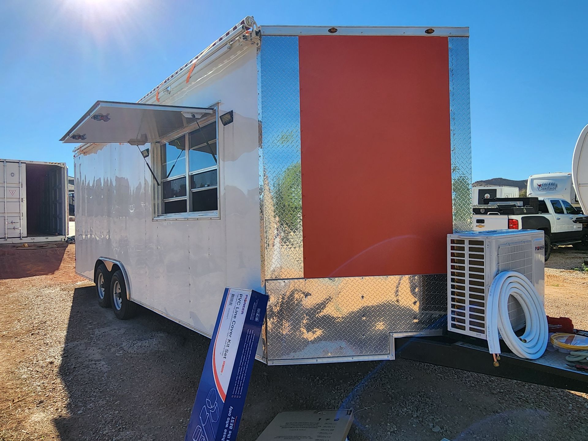 White food trailer with red and silver accents, open window, and air conditioning unit.