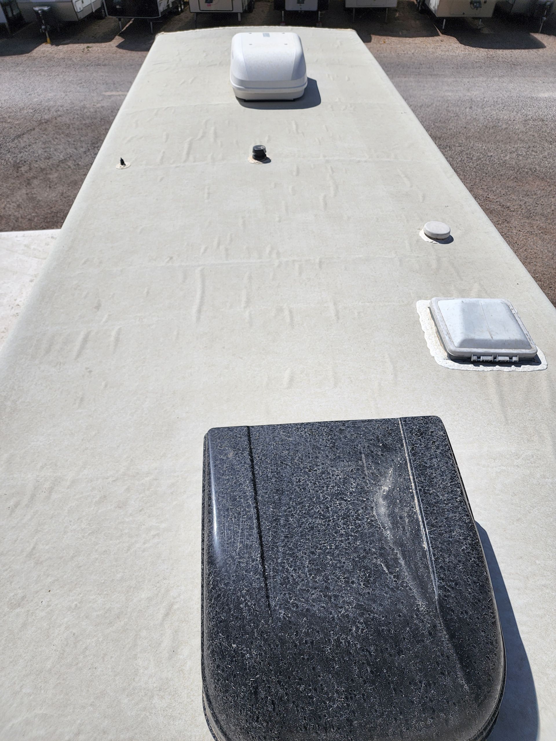 RV roof with various vents and fixtures, light gray color.