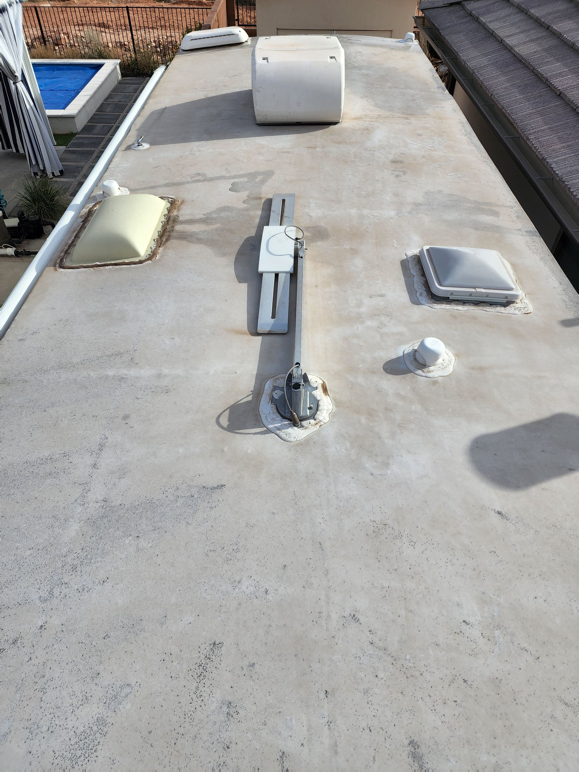 RV roof with vents, skylights, and electrical components. Gray surface with white fixtures.