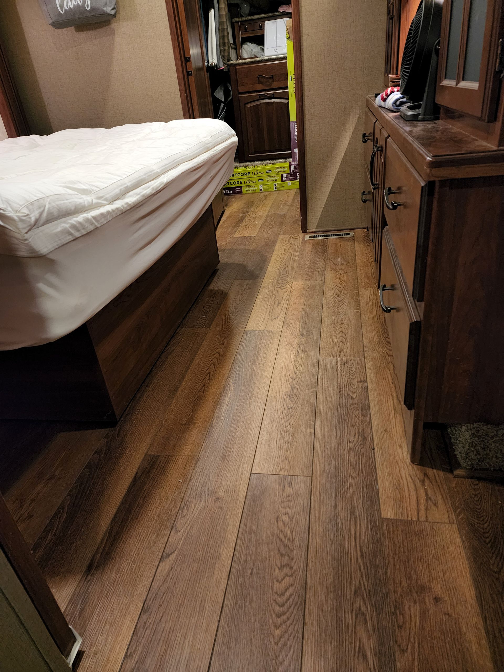 Bedroom with wood floor, bed, dresser, and closet in the background.