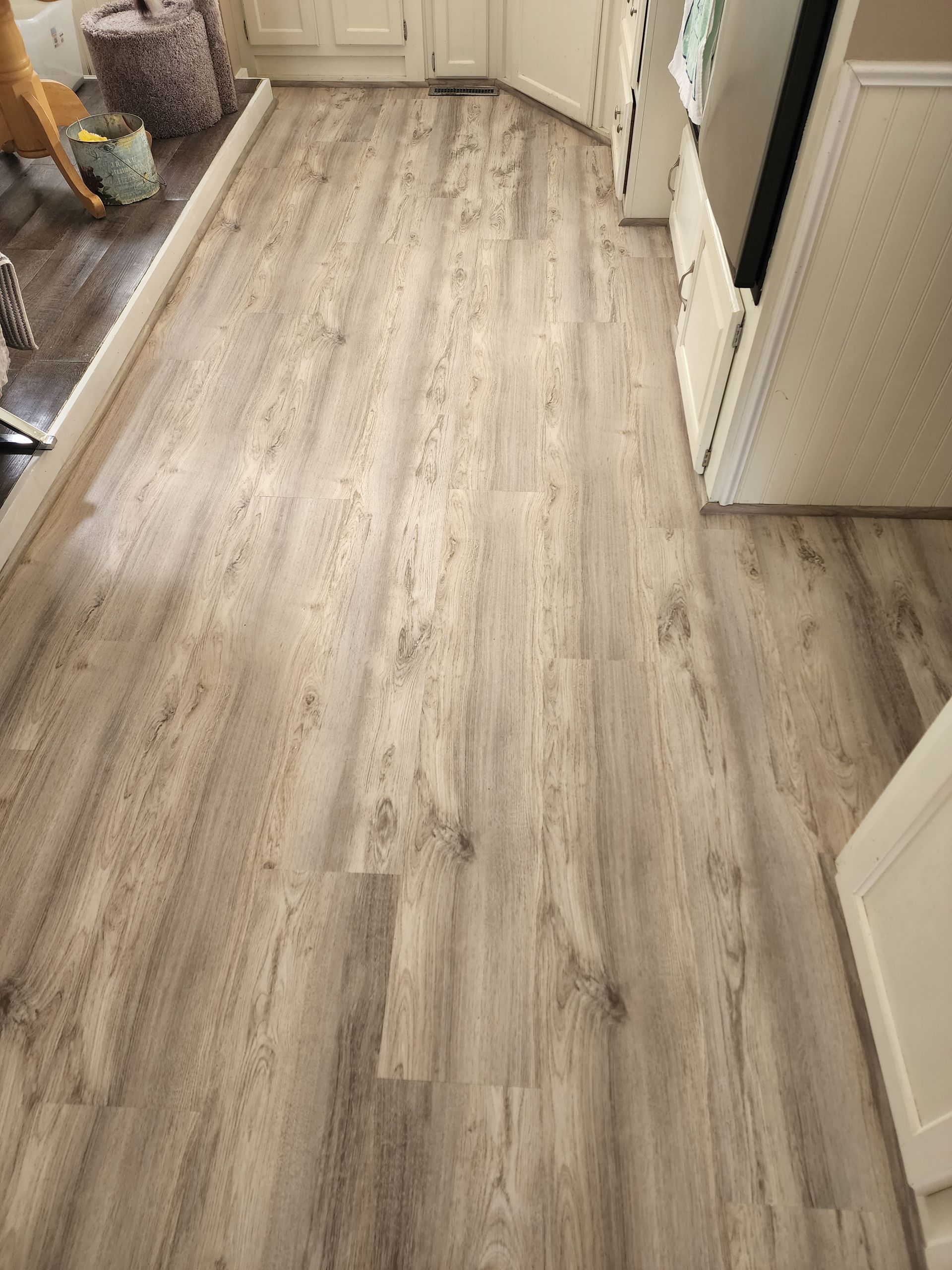 Light wood-look vinyl flooring in a kitchen.