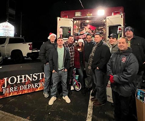 Johnston Fire Department members with donations by ambulance at night.