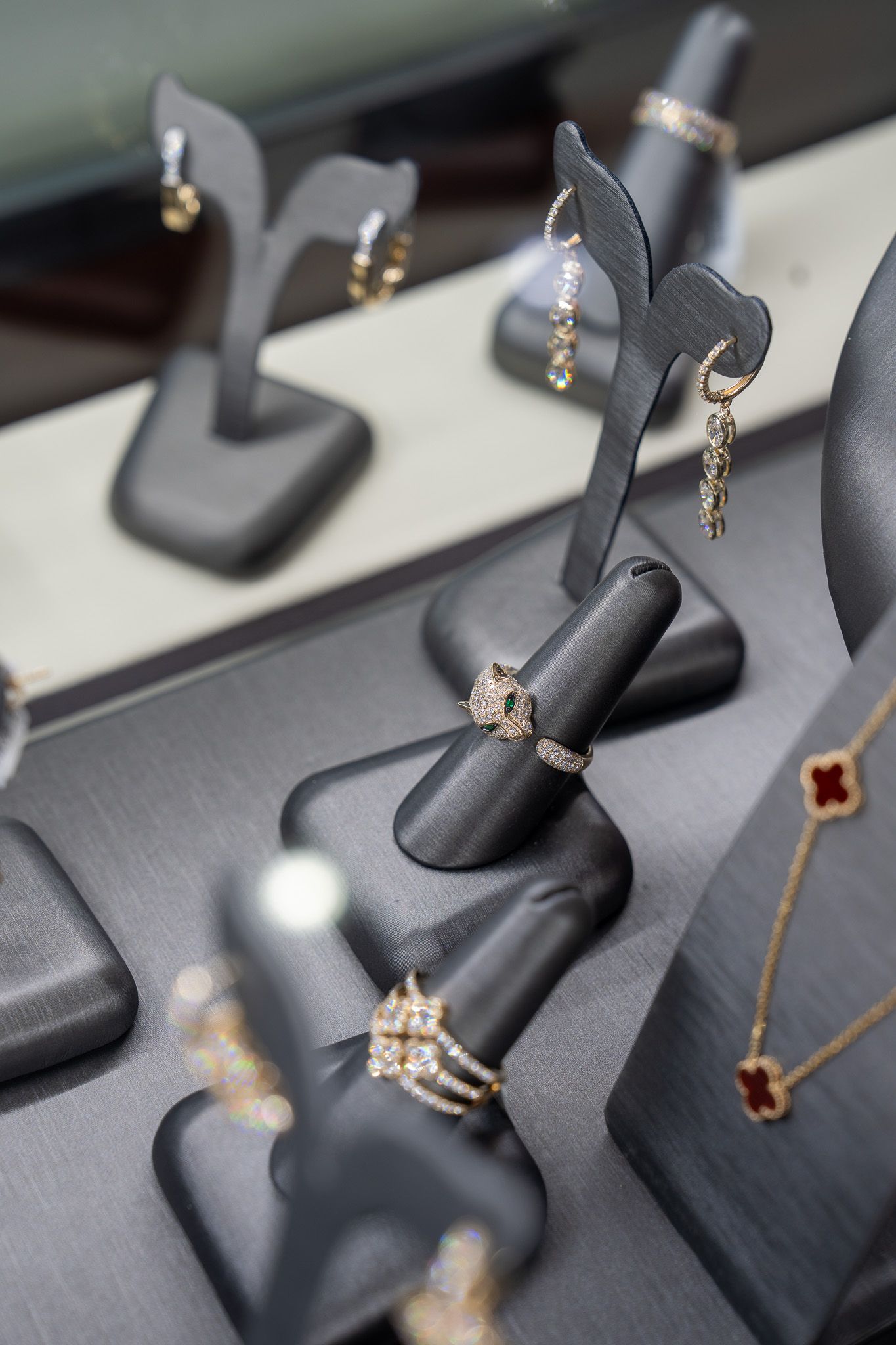 Jewelry display with black velvet stands holding gold rings and butterfly earrings