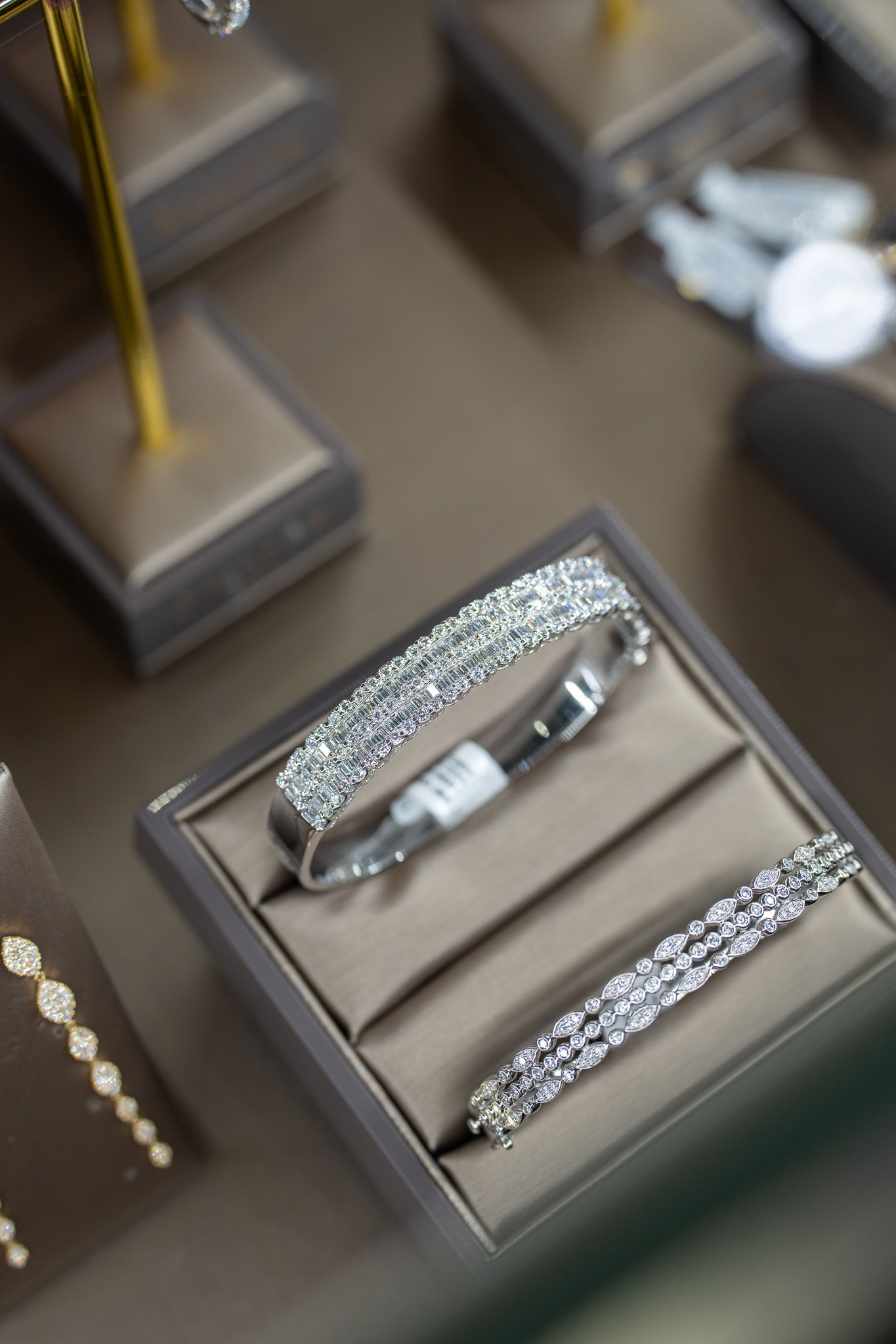 Bracelet on a display stand in a jewelry store, surrounded by sparkling silver accessories.