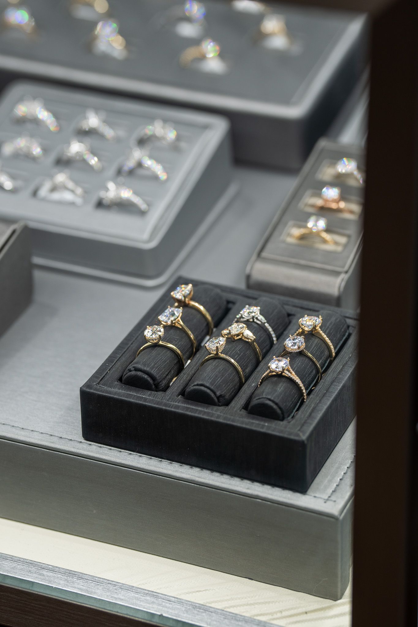 Black braided bracelets displayed in a gray jewelry case with other accessories.