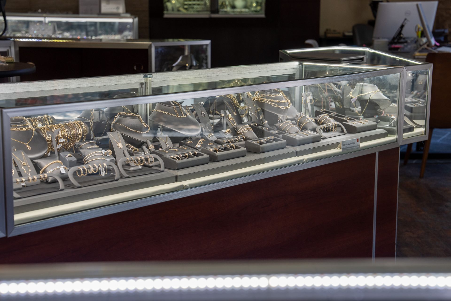 Glass display case filled with assorted jewelry and watches in a store interior