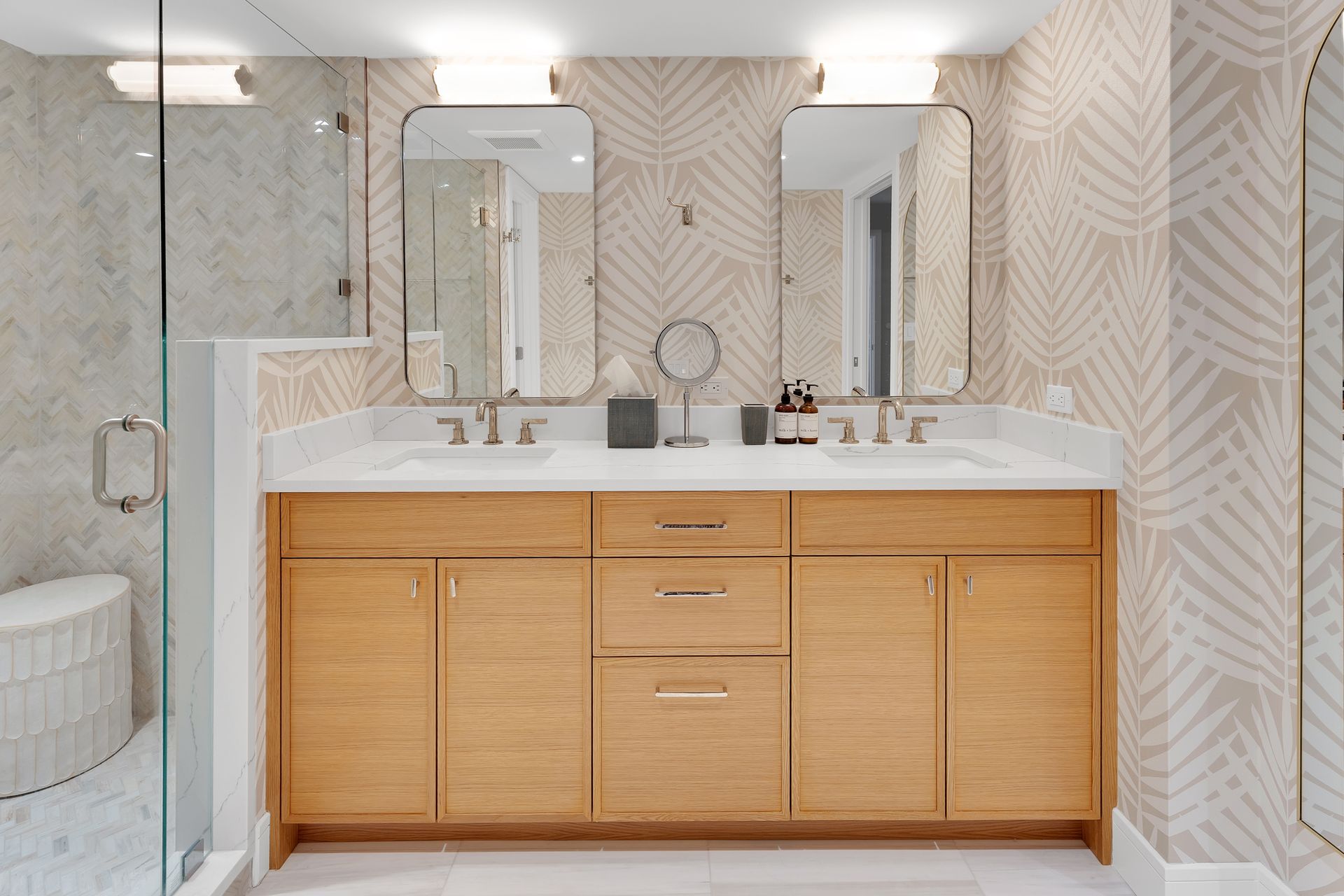 Modern bathroom with wood vanity, twin mirrors, and beige geometric tile walls
