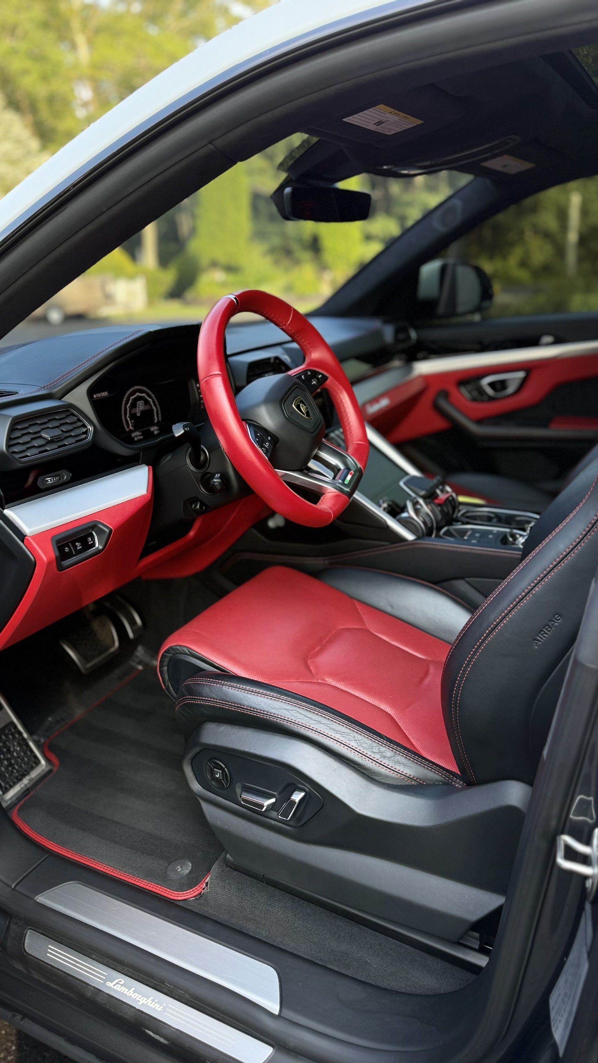 Black and red sports car interior with custom steering wheel and seats, door open