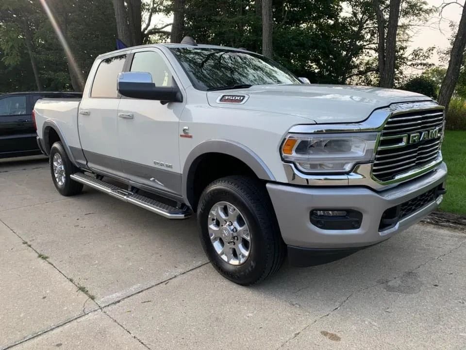 White Ram 3500 pickup truck parked on concrete. Silver accents, chrome grille.