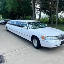 White limousine parked on a paved surface outdoors.