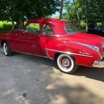 Red classic car parked outdoors.
