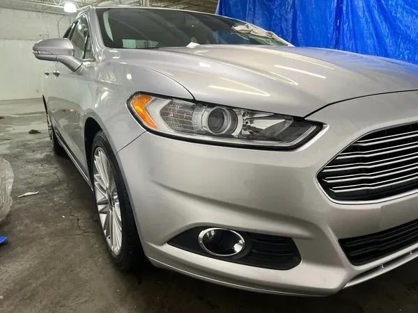 Silver Ford Fusion car, parked indoors, angled front view.