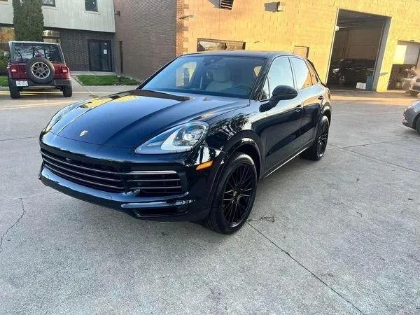 Black Porsche Cayenne SUV parked outside a building.