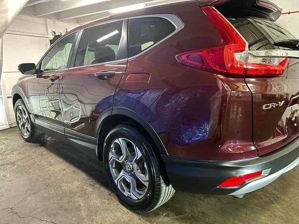 Maroon Honda CR-V SUV parked in a garage.