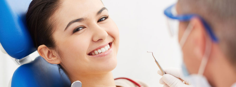 A woman getting her teeth checked by a dentist