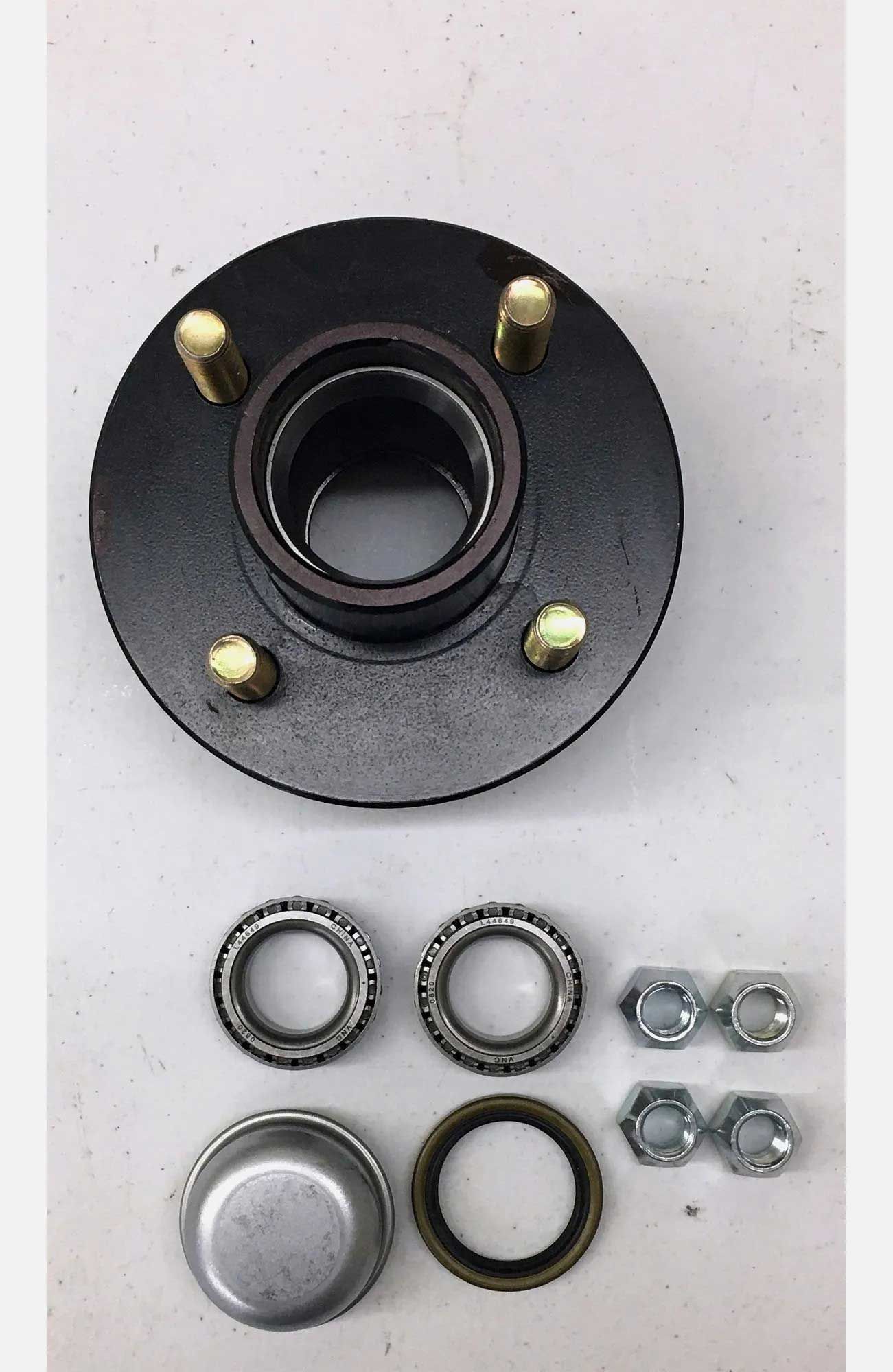 Black trailer hub with gold studs, surrounded by bearings, seals, and nuts.