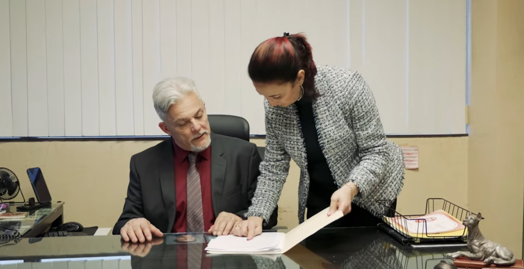 Doctor consulting with a couple in an office; all wear masks.