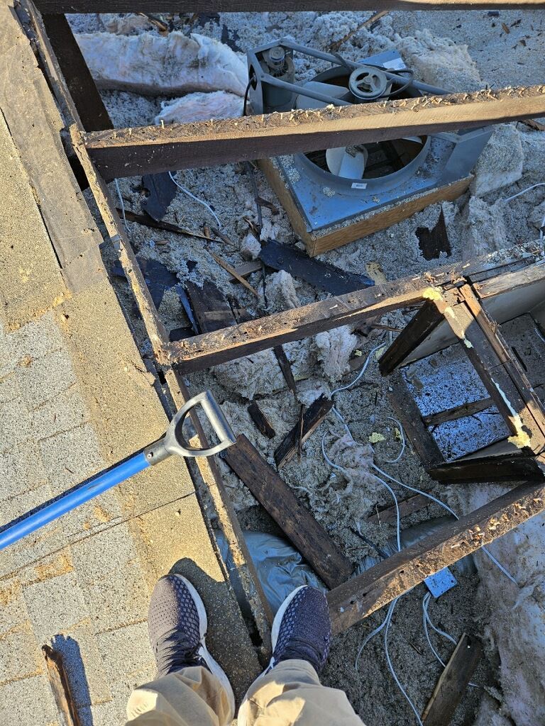 A person is holding a shovel over a pile of wood.
