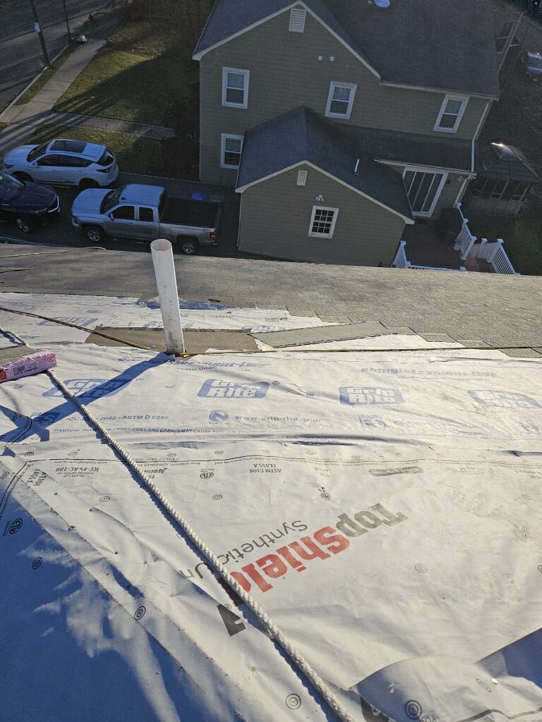 An aerial view of a roof with a tarp that says topshield on it