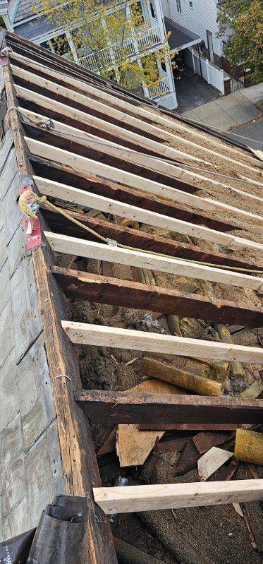 A roof with wooden beams being installed on it.