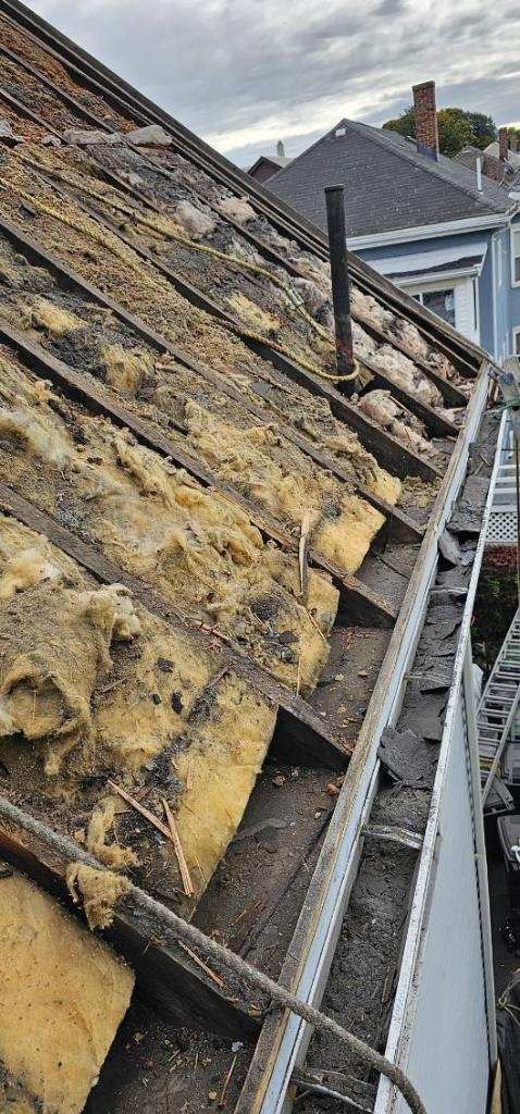 A close up of a roof with a gutter and a ladder.