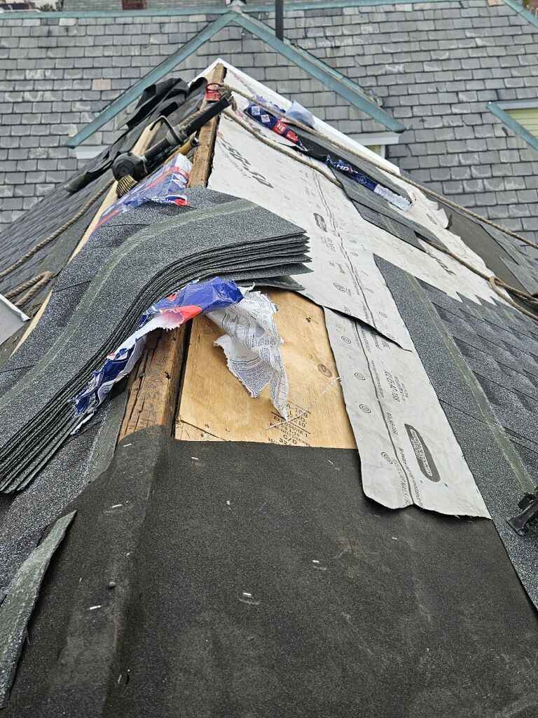 A roof with a lot of shingles on it is being repaired.