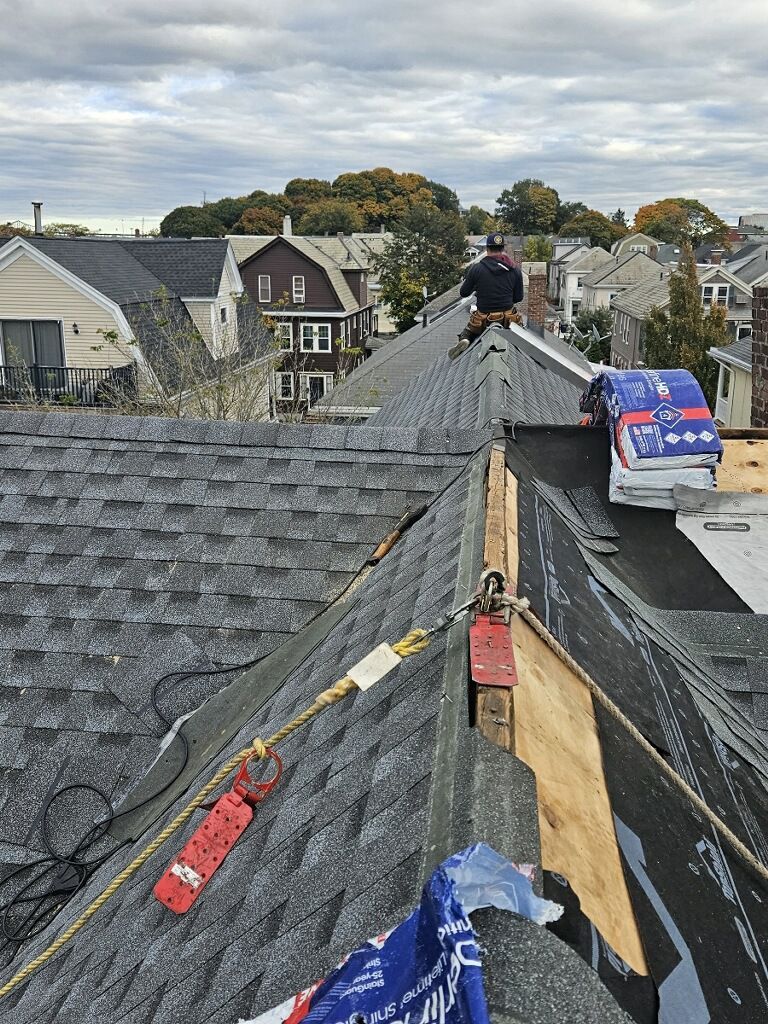 A man is sitting on the roof of a house.