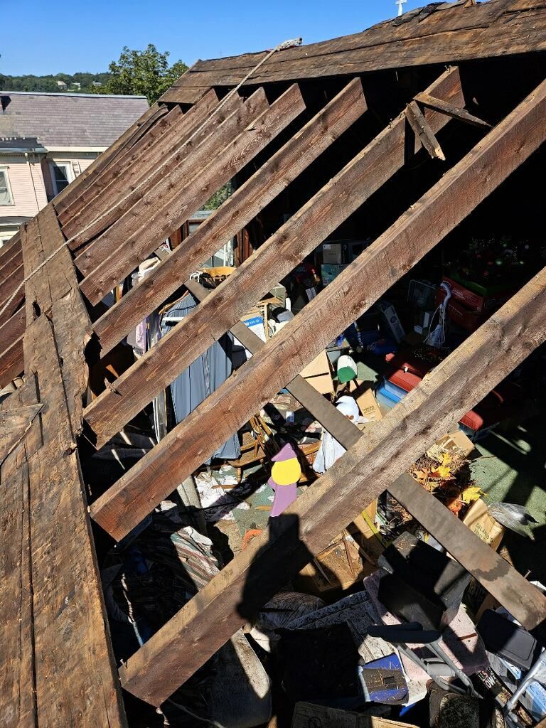 A roof with a lot of wooden beams and boxes on it.