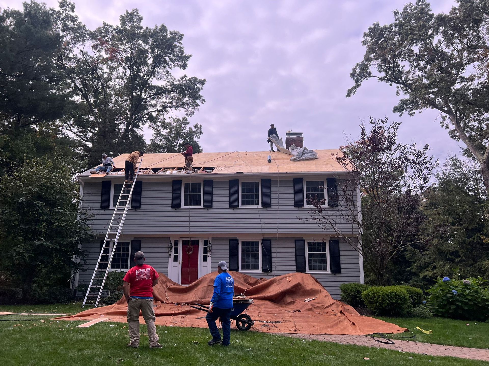 A group of men are working on the roof of a house
