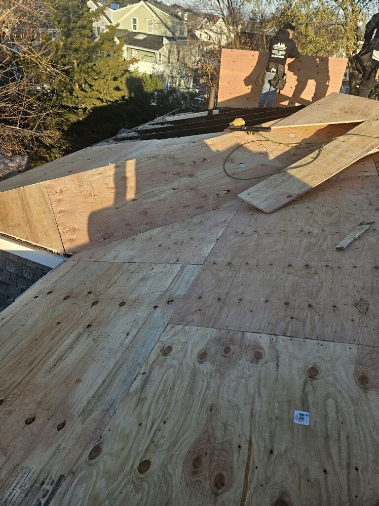 A man is standing on top of a wooden roof.