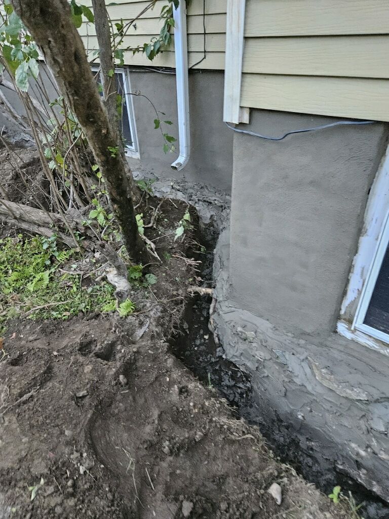 A house with a hole in the ground in front of it.