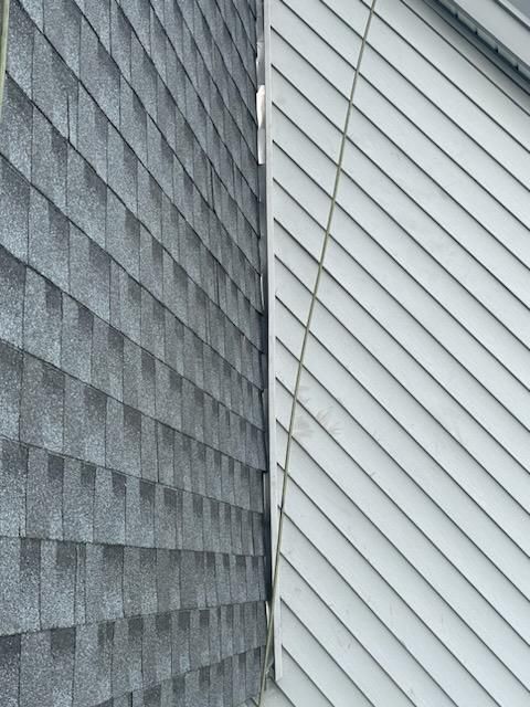 A close up of a gray siding on a white house.