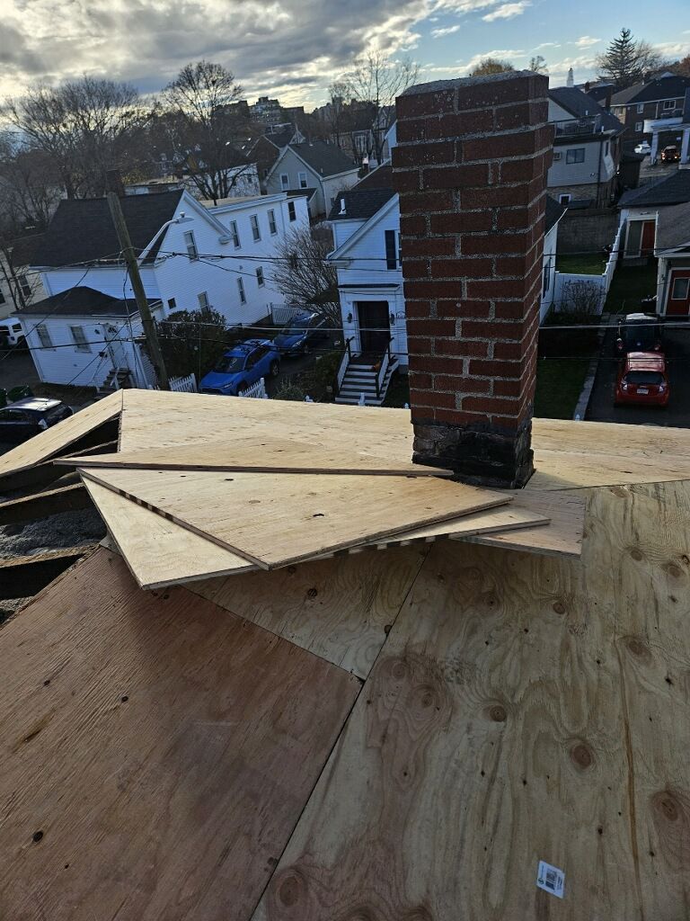 A brick chimney is sitting on top of a wooden roof.