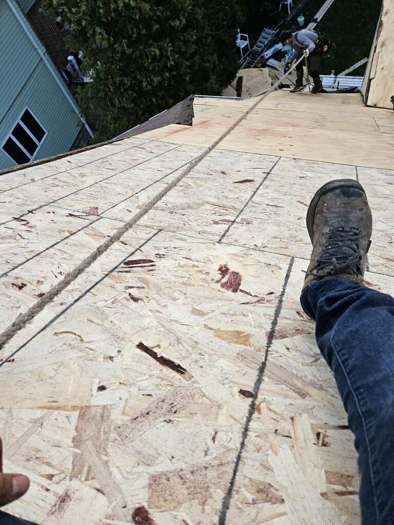 A person is laying on top of a wooden roof.