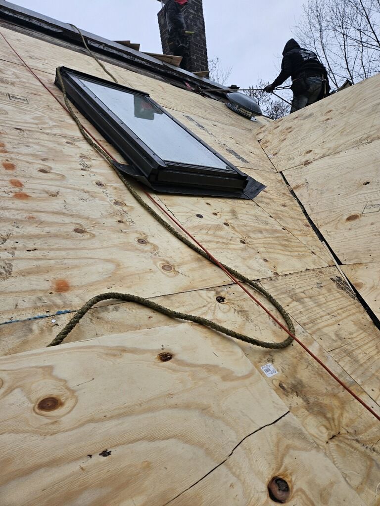 A man is working on a roof with a skylight.