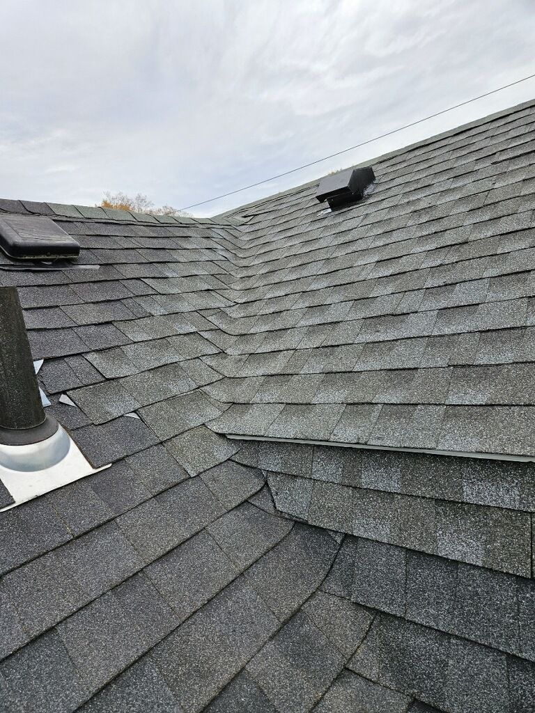 A close up of a roof with shingles and a chimney.