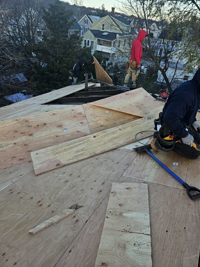 A man is sitting on top of a wooden roof.
