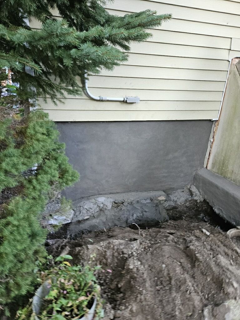 There is a hole in the ground in front of a house.
