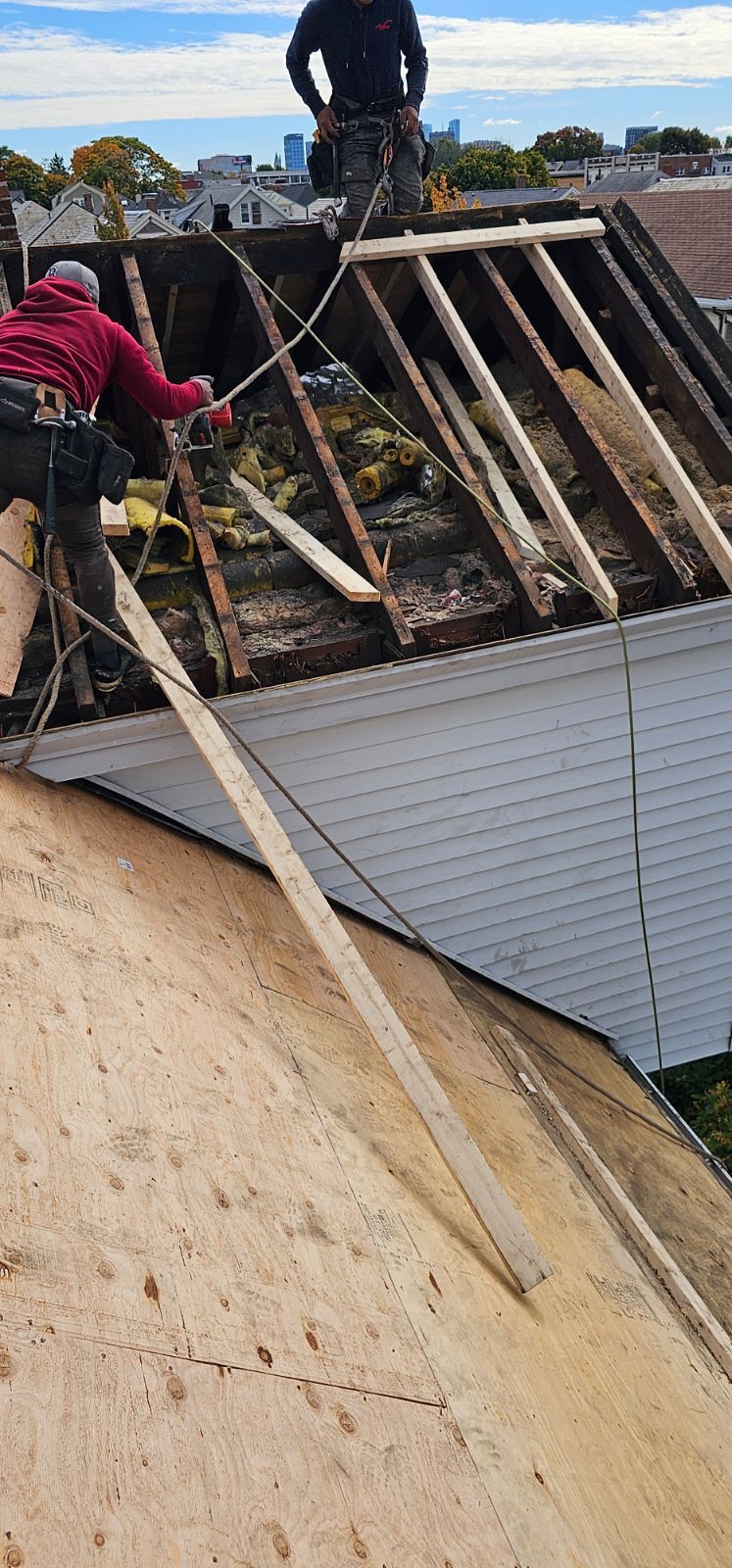 Two men are working on the roof of a house.