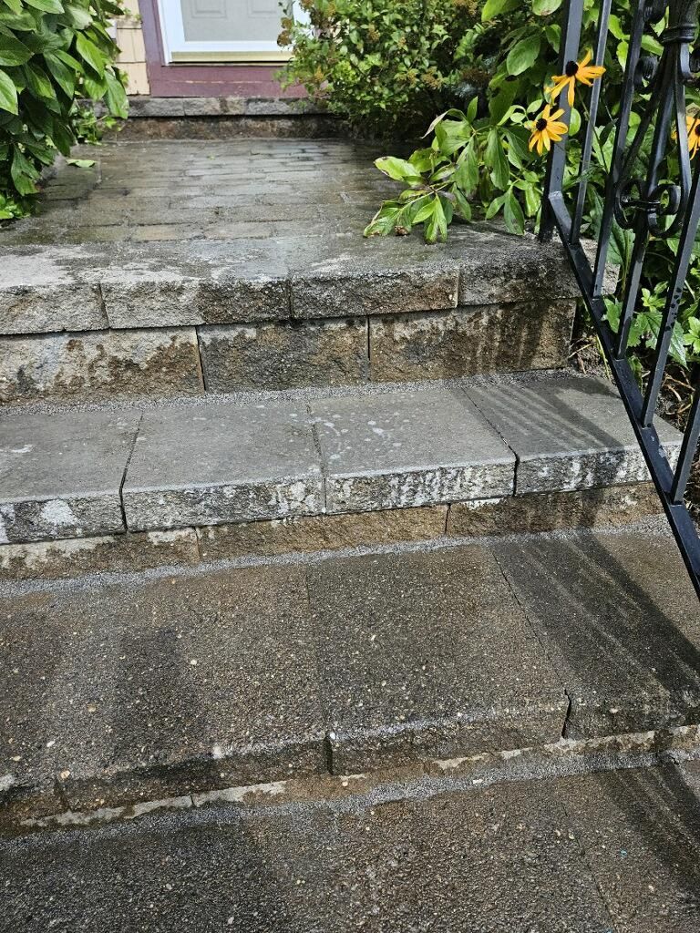 A set of stairs leading up to a house with a railing.